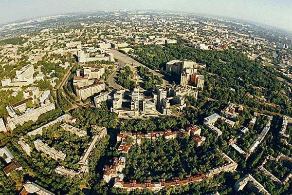 Фотография. Не кликабельно. В расположенном на холмистой равнине городе много зелени.