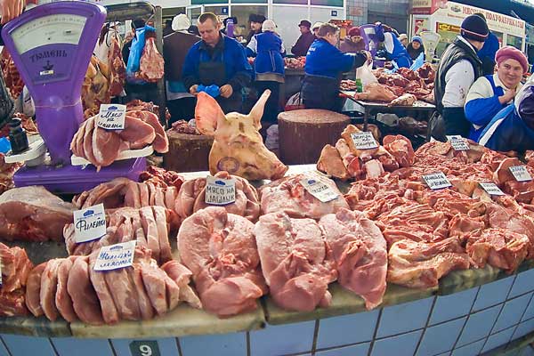 Потребители покупают свежее мясо на рынке.