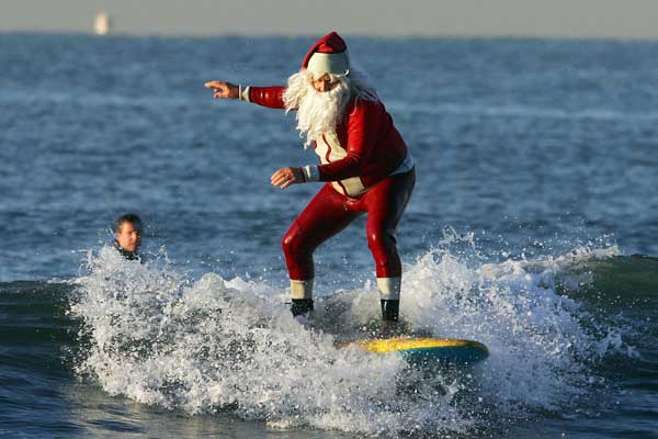 На серферной доске прямо из океана возникает Санта.
